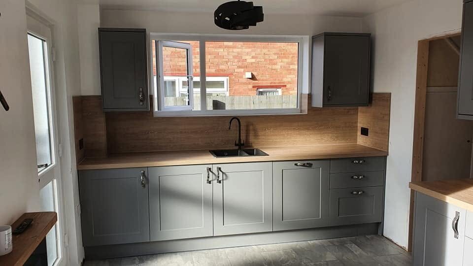 Completed sink run with Linear Oak Effect worktops and matching backboards