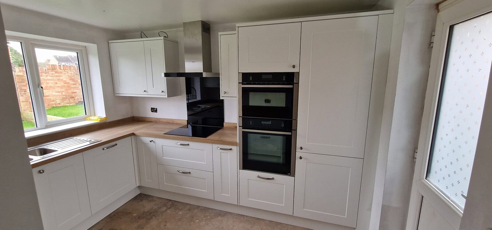 Completed Chelford White kitchen with integrated NEFF ovens and hob