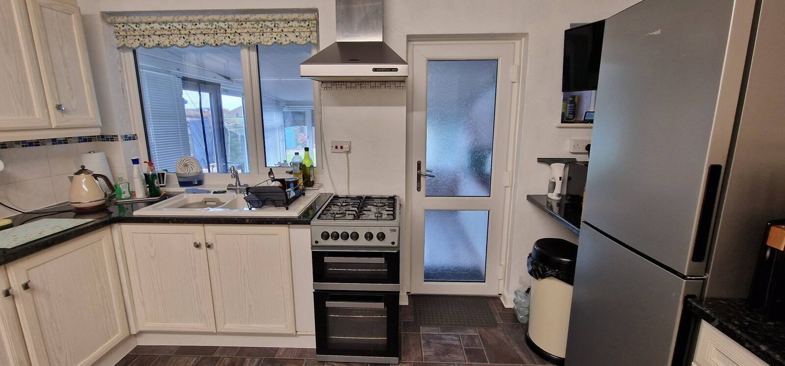 Older white kitchen before its grey gloss transformation, cooking area